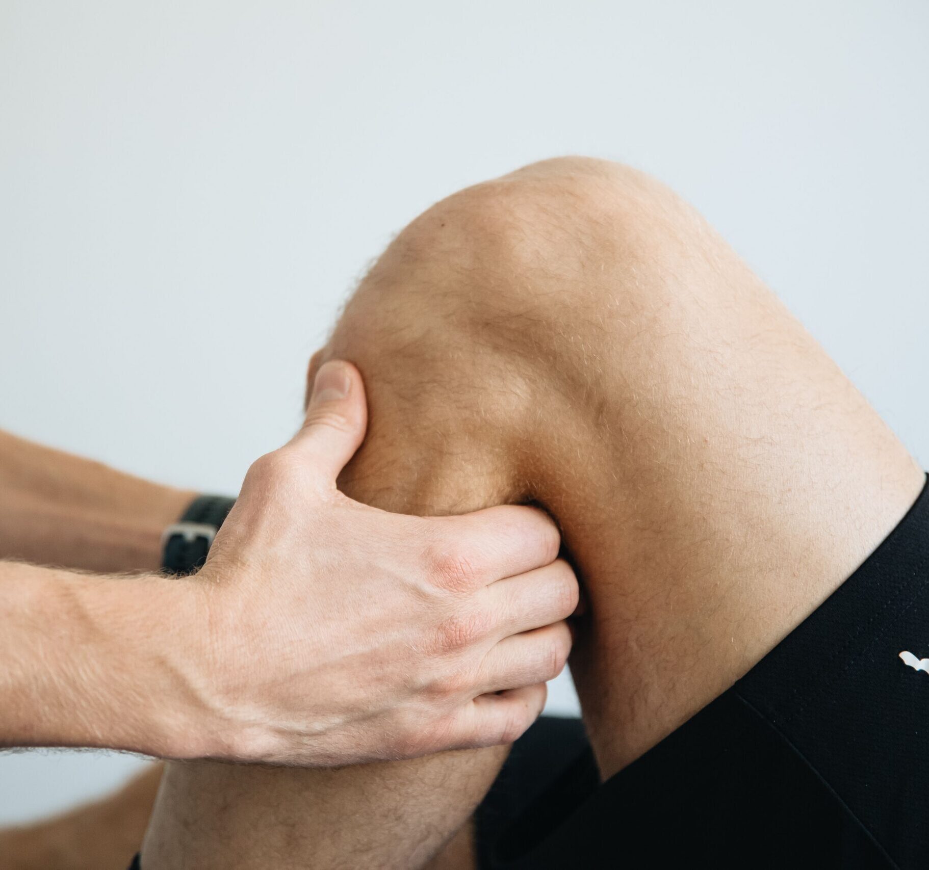 Detailed image of a physiotherapy session focusing on knee massage treatment.