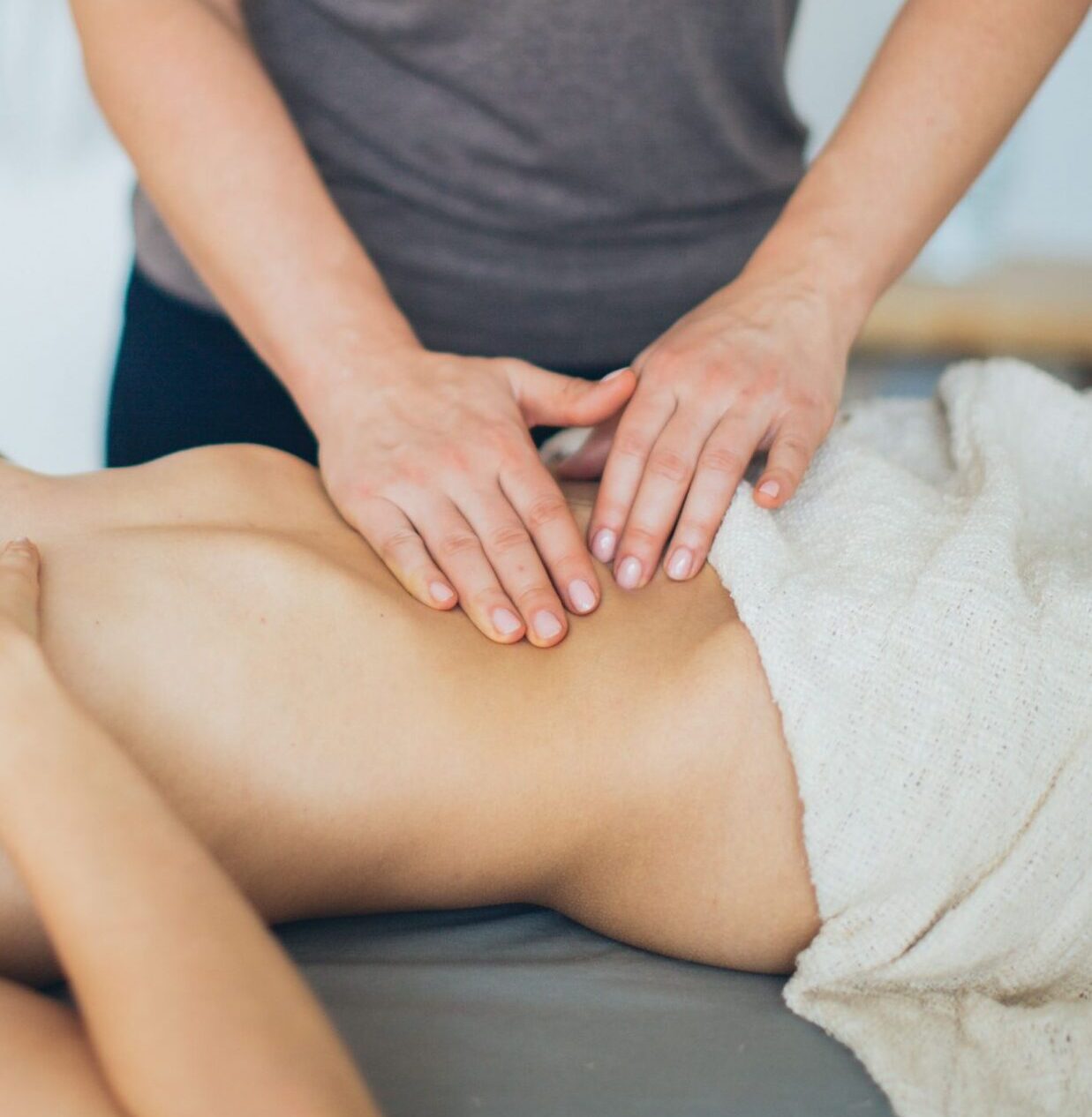 A calming indoor massage session with a woman receiving a spa treatment, enhancing relaxation.